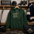 Youth forest green hockey hoodie featuring a vintage "Toughest Game Around" hockey player graphic displayed in a hockey locker room setting.
