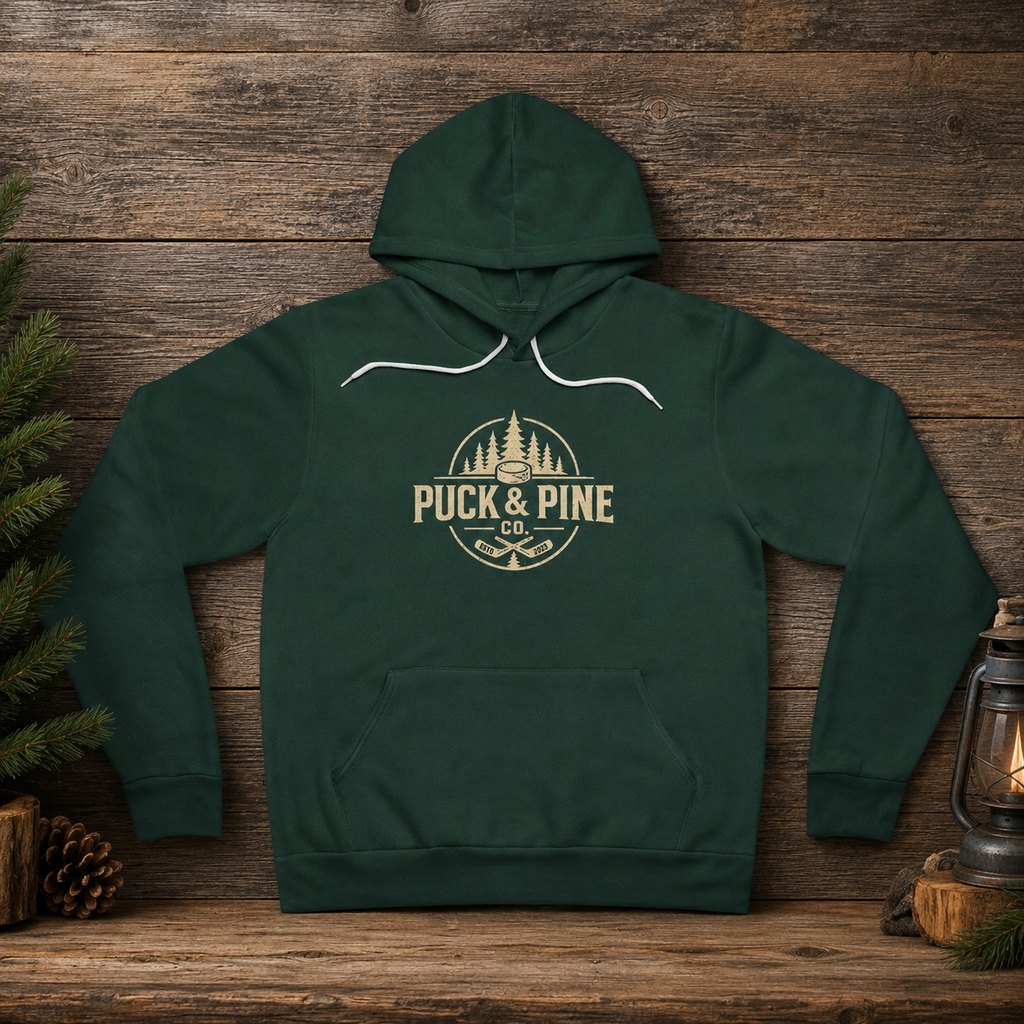 Forest green Puck & Pine Co. hockey hoodie featuring vintage outdoor logo with pine trees and hockey sticks